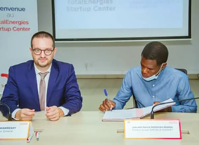 Le DG de TotalEnergies (à g.) pendant la signature du contrat avec un lauréat