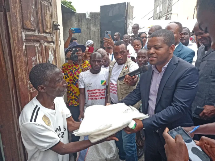 Letchaud Oko B. remettant la moustiquaire à un habitant