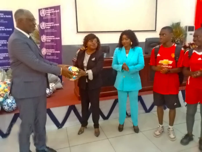 Dr Lucien Alexis Manga remettant un ballon symboliquement à Mme Régine Tchicaya Oboa