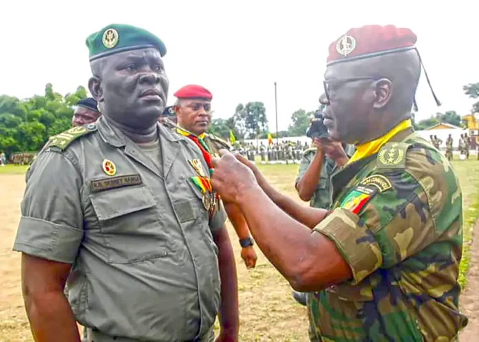 Le général Okoï faisant porter les galons à un officier promu Le général Okoï faisant porter les galons à un officier promu