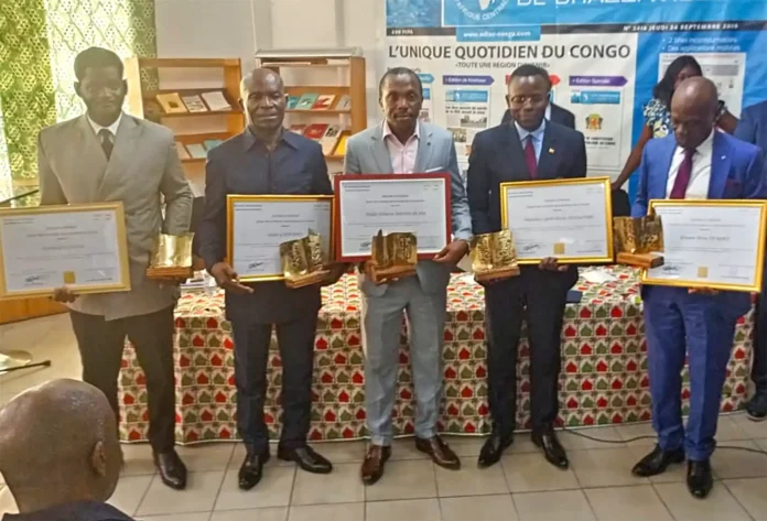Les écrivains distingués tenant leurs prix