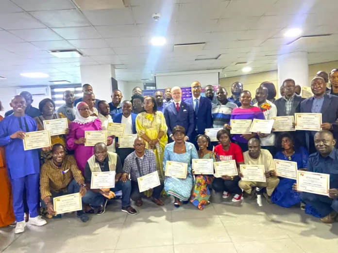 Les participants aux côtés des officiels recevant leur certificat